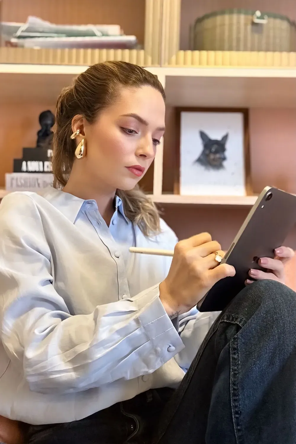 Dra. Amanda Arnoni trabalhando, com caneta e tablet nas mãos